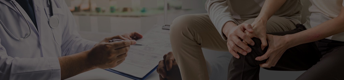 전문의가 환자의 무릎을 짚으며 진찰하는 모습